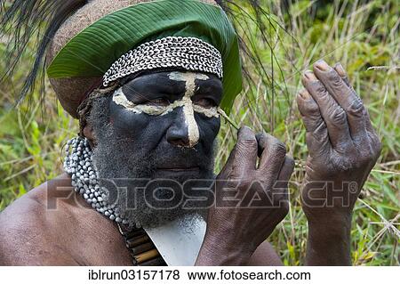 "Traditionally dressed tribal chief applying face paint, Hochland, Paya, Highland, Papua New Guinea, Oceania" View Large Photo Image Stock Photo - "Traditionally dressed tribal chief applying face paint, Hochland, Paya, Highland, Papua New Guinea, Oceania". Fotosearch