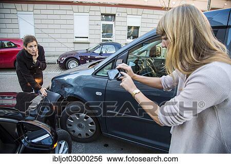 "Traffic accident, slight body damage to a car, crash while turning from an exit, woman involved in the accident taking a photo with her cell phone of the damage to the vehicle, Germany, Europe" View Large Photo Image Stock Photograph - "Traffic accident, slight body damage to a car, crash while turning from an exit, woman involved in the accident taking a photo with her cell phone of the damage to the vehicle, Germany, Europe". Fotosearch