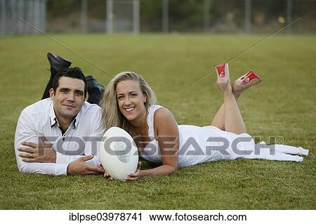 "Trash the dress, bride and groom lying on a rugby pitch with a rugby ball" View Large Photo Image Stock Image - "Trash the dress, bride and groom lying on a rugby pitch with a rugby ball". Fotosearch