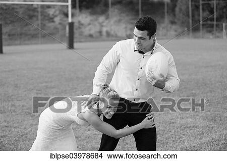 "Trash the dress, bride and groom playing rugby" View Large Photo Image Picture - "Trash the dress, bride and groom playing rugby". Fotosearch