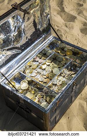 Treasure chest with gold and silver coins on the sand View Large Photo Image Stock Image - Treasure chest with gold and silver coins on the sand. Fotosearch