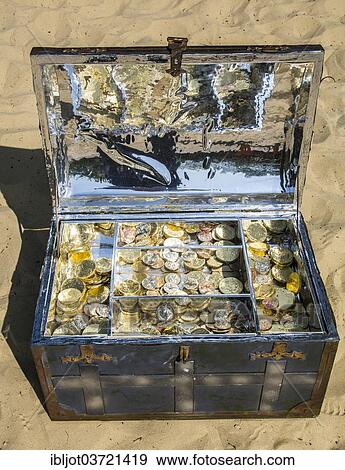 Treasure chest with gold and silver coins on the sand View Large Photo Image Stock Photo - Treasure chest with gold and silver coins on the sand. Fotosearch