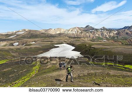 "Trekking in mountain landscape, hiking group, snowfield, rhyolite rocks, Blahnjukur volcano at the back, Landmannalaugar, Rangarping ytra, Suourland, Iceland, Scandinavia, Europe" View Large Photo Image Stock Image - "Trekking in mountain landscape, hiking group, snowfield, rhyolite rocks, Blahnjukur volcano at the back, Landmannalaugar, Rangarping ytra, Suourland, Iceland, Scandinavia, Europe". Fotosearch