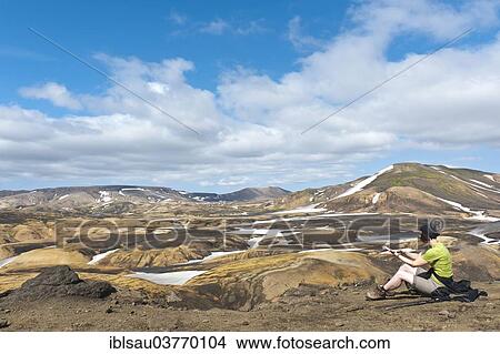 "Trekking in the highlands, woman resting, vast mountain landscape and snowfields, Laugavegur hiking trail, near Hrafntinnusker, Rangarping ytra, Suourland, Iceland, Scandinavia, Europe" View Large Photo Image Picture - "Trekking in the highlands, woman resting, vast mountain landscape and snowfields, Laugavegur hiking trail, near Hrafntinnusker, Rangarping ytra, Suourland, Iceland, Scandinavia, Europe". Fotosearch