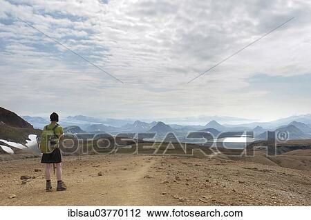 "Trekking in the highlands, woman standing in front of a vast expanse with views of a mountain landscape, Laugavegur hiking trail, near Lake Alftavatn, Rangarping ytra, Suourland, Iceland, Scandinavia, Europe" View Large Photo Image Stock Image - "Trekking in the highlands, woman standing in front of a vast expanse with views of a mountain landscape, Laugavegur hiking trail, near Lake Alftavatn, Rangarping ytra, Suourland, Iceland, Scandinavia, Europe". Fotosearch