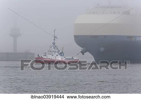Picture - "Tugboat hauling a freighter in fog, Port of Hamburg, Hamburg, Germany, Europe". Fotosearch