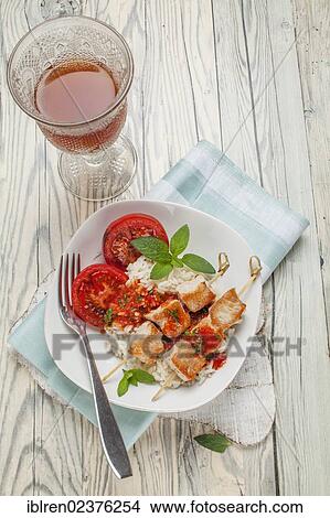 Turkey skewers on rice with tomato sauce and grilled tomatoes View Large Photo Image Picture - Turkey skewers on rice with tomato sauce and grilled tomatoes. Fotosearch