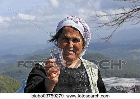 "Turkish woman passing a glass in Akyaka, Mugla Province, Turkey, Asia" View Large Photo Image Stock Photo - "Turkish woman passing a glass in Akyaka, Mugla Province, Turkey, Asia". Fotosearch