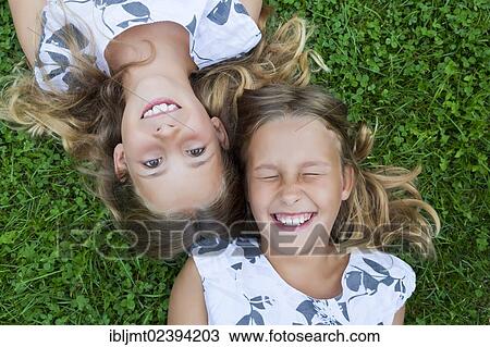 "Twin girls, 9, lying on the grass" View Large Photo Image Stock Image - "Twin girls, 9, lying on the grass". Fotosearch