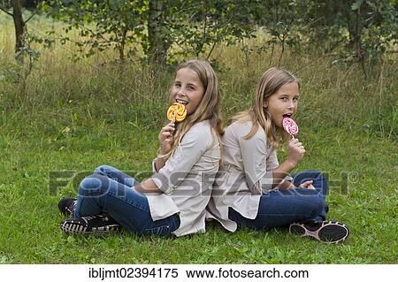 "Twin girls, 9, with colourful lollipops" View Large Photo Image Stock Photography - "Twin girls, 9, with colourful lollipops". Fotosearch