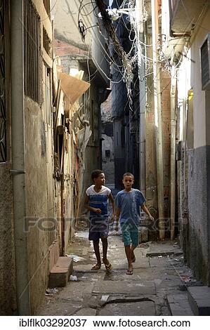 "Two boys in a narrow alley in a slum or favela, Jacarezinho favela, Rio de Janeiro, Rio de Janeiro State, Brazil, South America" View Large Photo Image Stock Photo - "Two boys in a narrow alley in a slum or favela, Jacarezinho favela, Rio de Janeiro, Rio de Janeiro State, Brazil, South America". Fotosearch