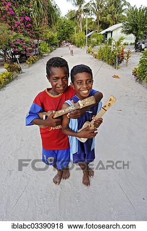 Stock Photo - "Two boys with ukulele toys, Arborek, Raja Ampat, West Papua, Indonesia, Asia". Fotosearch