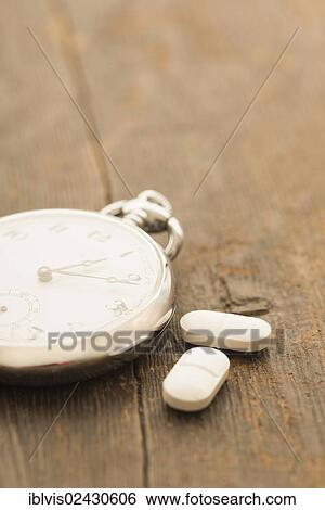 Two capsules next to retro pocket watch View Large Photo Image Stock Photograph - Two capsules next to retro pocket watch. Fotosearch