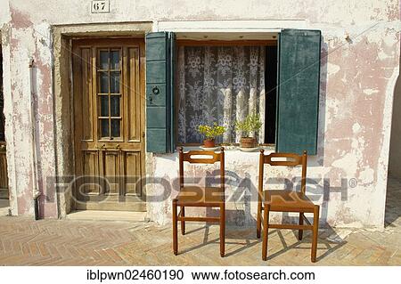 Stock Image - "Two chairs outside an old house, Burano, Venice, Italy, Europe". Fotosearch
