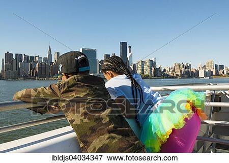 "Two children on a ferry, skyline of Manhattan at the back, Manhattan, New York, United States, North America" View Large Photo Image Stock Photo - "Two children on a ferry, skyline of Manhattan at the back, Manhattan, New York, United States, North America". Fotosearch
