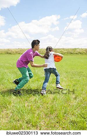 Two children playing ball on a meadow View Large Photo Image Stock Image - Two children playing ball on a meadow. Fotosearch