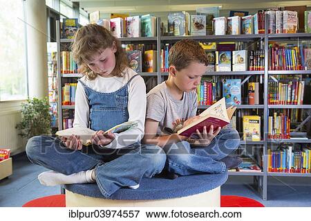"Two children reading reading books in a public library, Coswig, Saxony, Germany, Europe" View Large Photo Image Stock Photo - "Two children reading reading books in a public library, Coswig, Saxony, Germany, Europe". Fotosearch