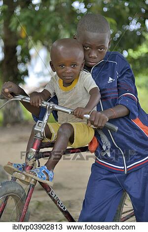 "Two children with a bicycle, Nkala, Bandundu Province, Democratic Republic of the Congo" View Large Photo Image Stock Image - "Two children with a bicycle, Nkala, Bandundu Province, Democratic Republic of the Congo". Fotosearch