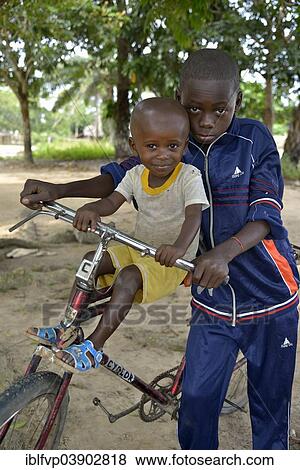 "Two children with a bicycle, Nkala, Bandundu Province, Democratic Republic of the Congo" View Large Photo Image Stock Photo - "Two children with a bicycle, Nkala, Bandundu Province, Democratic Republic of the Congo". Fotosearch