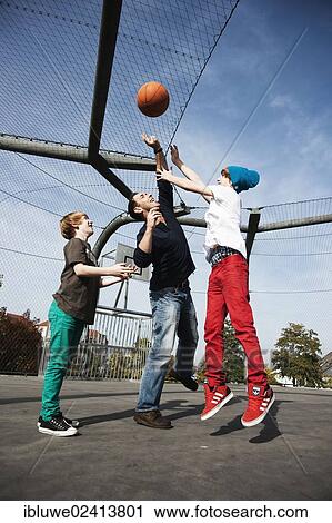 Stock Image - Two cool boys playing basketball with their father. Fotosearch