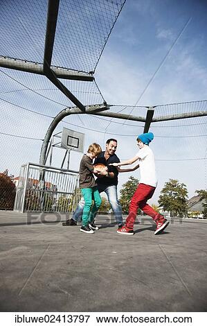 Two cool boys playing basketball with their father View Large Photo Image Stock Photo - Two cool boys playing basketball with their father. Fotosearch