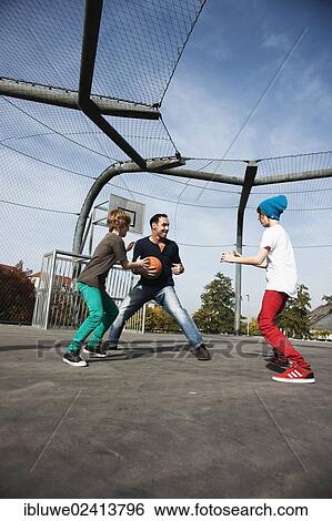 Two cool boys playing basketball with their father View Large Photo Image Stock Photograph - Two cool boys playing basketball with their father. Fotosearch