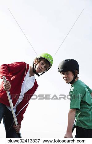 Two cool boys playing roller hockey with hockey sticks View Large Photo Image Stock Photo - Two cool boys playing roller hockey with hockey sticks. Fotosearch