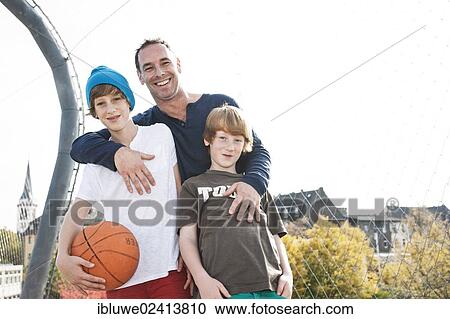 Two cool boys standing with their father on a playground View Large Photo Image Stock Image - Two cool boys standing with their father on a playground. Fotosearch