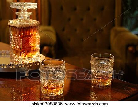 Two filled whiskey glasses and a decanter View Large Photo Image Stock Photograph - Two filled whiskey glasses and a decanter. Fotosearch