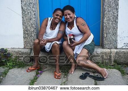 "Two friendly women sitting on the doorstep, Paraty, Rio de Janeiro State, Brazil, South America" View Large Photo Image Stock Photo - "Two friendly women sitting on the doorstep, Paraty, Rio de Janeiro State, Brazil, South America". Fotosearch