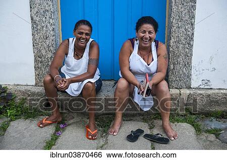 "Two friendly women sitting on the doorstep, Paraty, Rio de Janeiro State, Brazil, South America" View Large Photo Image Stock Photograph - "Two friendly women sitting on the doorstep, Paraty, Rio de Janeiro State, Brazil, South America". Fotosearch
