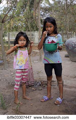 "Two girls brushing their teeth outside a house, hygiene education, Lompong Commune, Bathi District, Takeo Province, Cambodia, Asia" View Large Photo Image Stock Photo - "Two girls brushing their teeth outside a house, hygiene education, Lompong Commune, Bathi District, Takeo Province, Cambodia, Asia". Fotosearch