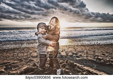 Two girls standing on the beach View Large Photo Image Stock Photograph - Two girls standing on the beach. Fotosearch