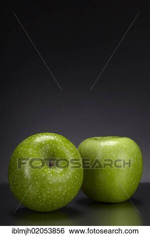 Two green Granny Smith apples on a dark glass plate View Large Photo Image Stock Photograph - Two green Granny Smith apples on a dark glass plate. Fotosearch