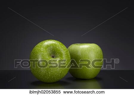 Two green Granny Smith apples on a dark glass plate View Large Photo Image Stock Photography - Two green Granny Smith apples on a dark glass plate. Fotosearch