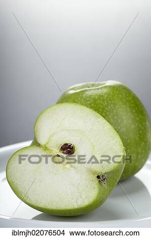 "Two green Granny Smith apples, one whole apple and one apple cut in half" View Large Photo Image Picture - "Two green Granny Smith apples, one whole apple and one apple cut in half". Fotosearch