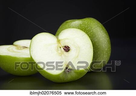 "Two green Granny Smith apples, one whole apple and one apple cut in half, on black glass plate" View Large Photo Image Stock Photography - "Two green Granny Smith apples, one whole apple and one apple cut in half, on black glass plate". Fotosearch