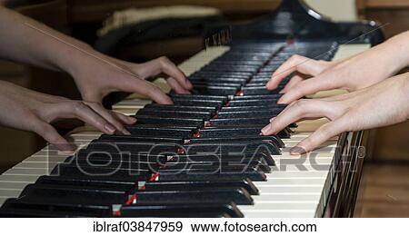 Stock Photo - Two hands playing a piano and being reflected in the instrument. Fotosearch