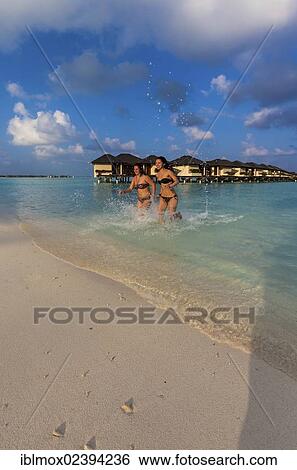 "Two happy girls, about 15 and 19 years old, running on a beach, lagoon, Paradise Island at the back, Lankanfinolhu, North Male Atoll, Republic of Maldives, Indian Ocean, Asia" View Large Photo Image Stock Photograph - "Two happy girls, about 15 and 19 years old, running on a beach, lagoon, Paradise Island at the back, Lankanfinolhu, North Male Atoll, Republic of Maldives, Indian Ocean, Asia". Fotosearch