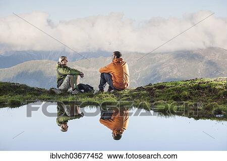 "Two hikers are reflected in a small lake, Sellraintal, Tyrol, Austria, Europe" View Large Photo Image Stock Image - "Two hikers are reflected in a small lake, Sellraintal, Tyrol, Austria, Europe". Fotosearch