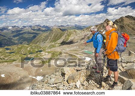 Picture - "Two hikers on the Fuorcia da Barcli pass, overlooking the Macun Lakes, Swiss National Park, Graubunden, Switzerland, Europe". Fotosearch