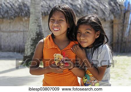 "Two Kuna Indian girls holding a small soft toy, in a Kuna Indian village, Nalunega, San Blas Islands, Panama, North America" View Large Photo Image Stock Photo - "Two Kuna Indian girls holding a small soft toy, in a Kuna Indian village, Nalunega, San Blas Islands, Panama, North America". Fotosearch