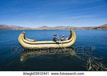 Stock Image - "Two local in a traditional rowing boat of Totora reed on Lake Titicaca, Peru, South America". Fotosearch