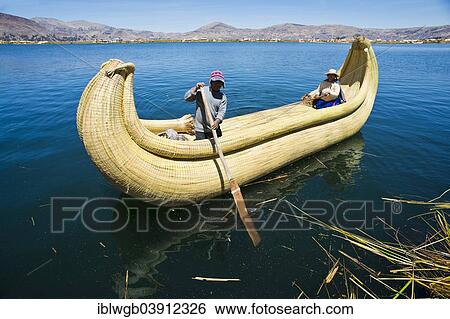 Stock Photograph - "Two local in a traditional rowing boat of Totora reed on Lake Titicaca, Peru, South America". Fotosearch