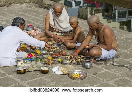 "Two men, a boy and a pandit or priest are performing Dashkriya or Asthi Visarjan, a ritual which is performed 10 days after the death of a family member, Nasik, Maharashtra, India, Asia" View Large Photo Image Stock Photo - "Two men, a boy and a pandit or priest are performing Dashkriya or Asthi Visarjan, a ritual which is performed 10 days after the death of a family member, Nasik, Maharashtra, India, Asia". Fotosearch