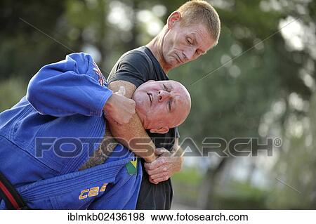 Stock Photo - Two men doing martial arts in a park. Fotosearch