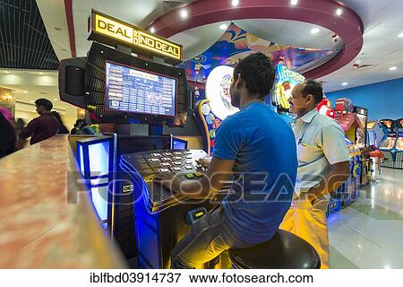 Stock Photo - "Two men playing at a gaming machine, Lulu Mall, Kochi, Kerala, India, Asia". Fotosearch