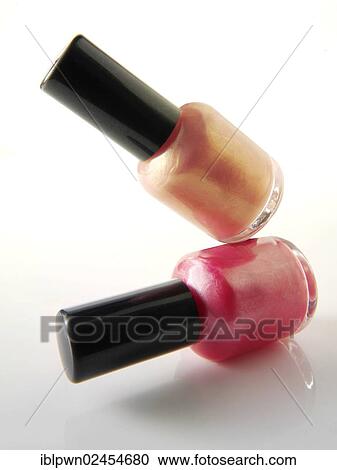 Stock Image - Two nail varnish bottles balanced on each other. Fotosearch