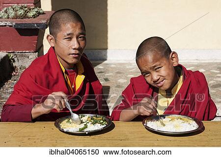 "Two novice monks eating a rice dish in the Buddhist Thrangu Tashi Yangtse Monastery near Namo Buddha, Nepal, Asia" View Large Photo Image Stock Image - "Two novice monks eating a rice dish in the Buddhist Thrangu Tashi Yangtse Monastery near Namo Buddha, Nepal, Asia". Fotosearch
