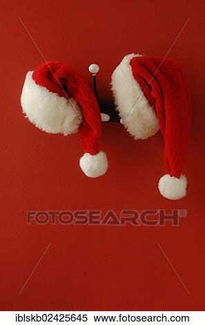 Two Santa hats on hanging on nostalgic coat hooks View Large Photo Image Stock Photography - Two Santa hats on hanging on nostalgic coat hooks. Fotosearch
